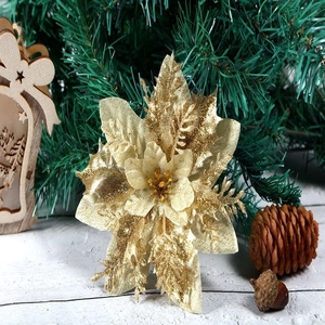 Close-up of golden glitter poinsettia flower on a pine branch for Christmas decor