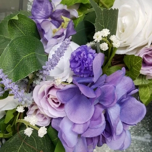 Close-up of purple hydrangeas and pink roses in a lifelike floral wreath arrangement