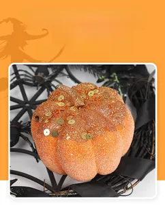 Close-up of orange glitter foam pumpkin on spider web base for Halloween decor