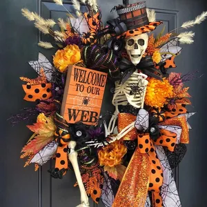Halloween skull wreath with orange flowers and welcome sign on a dark door