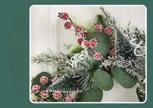Dettaglio di ghirlanda di cedro artificiale con bacche rosse, aghi di pino ed effetto neve