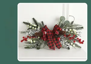 Close-up of Christmas rattan decoration with pine needles, cones and red plaid bow
