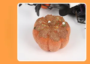 Detailed view of artificial Halloween pumpkin decorated with orange glitter and sequins