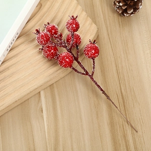 Artificial Christmas red berry stem with snow coating on light wooden board