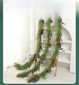 Nahaufnahme der künstlichen Weihnachtsgirlande mit roten Beeren und grünen Tannennadeln