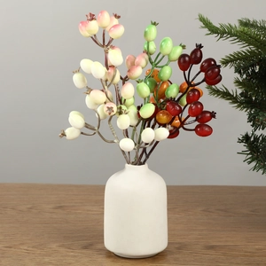 Baies de Noël artificielles dans un vase en céramique blanche pour décor de fête