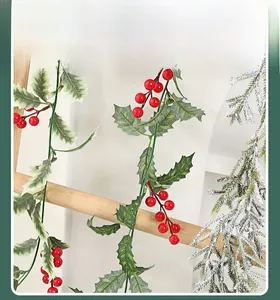 Detail of Christmas garland with red berries, holly leaves and snowy pine needles