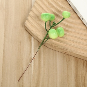 Close-up of artificial green berries on stem for Christmas decoration on wood background
