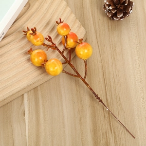 Close-up of artificial orange berries on brown stems for home holiday floral arrangements