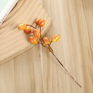 Branche de baies oranges artificielles pour décoration festive sur bureau en bois