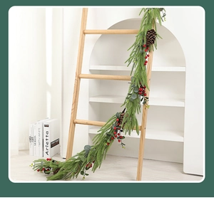 Detail der Weihnachtsgirlande mit roten Beeren und Zapfen an einer Holzleiter