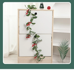 Close-up of artificial Christmas vine with red berries and green leaves for festive decoration