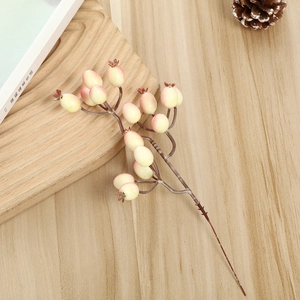 Détail macro de baies artificielles jaune-rose sur une surface en bois rustique