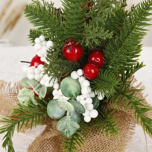 Christmas tabletop cedar decoration with red berries and pine needles in a burlap base