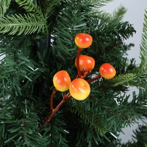 Close-up of glossy artificial red berries with green pine needles for Christmas decoration