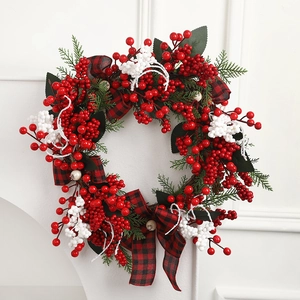 Christmas berry wreath with buffalo plaid bows and pine leaves for holiday door decor