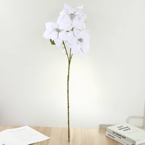 Three-head white artificial Christmas Poinsettia stem with silver center on a wood table