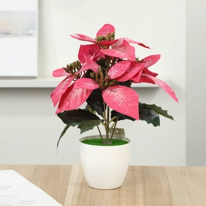 Detail of faux pink poinsettia plant in a white ceramic-style pot for home decor
