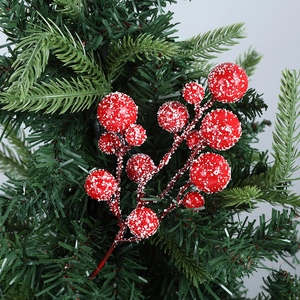 Detail of red Christmas berries with faux snow on green pine needles for festive decor