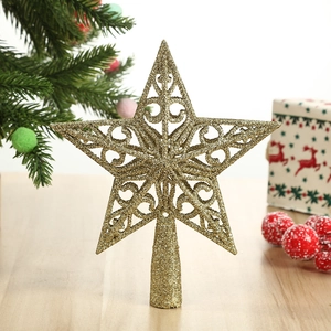 Glittering gold hollow star tree topper with intricate scrollwork on a festive tree