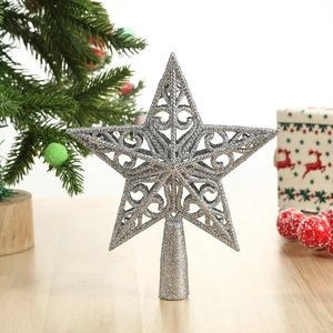 Hollow silver glitter star topper for Christmas tree decoration on wooden surface