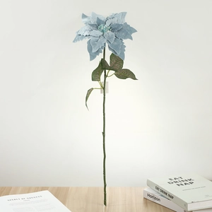 Détail de fleur de poinsettia artificielle bleu clair avec texture floquée sur table