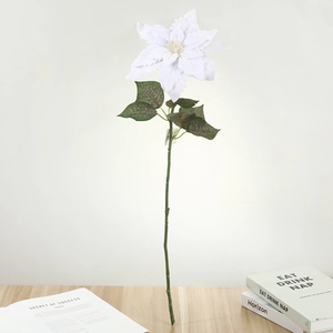 Détail d'un poinsettia artificiel blanc avec feuilles pour décoration de Noël festive