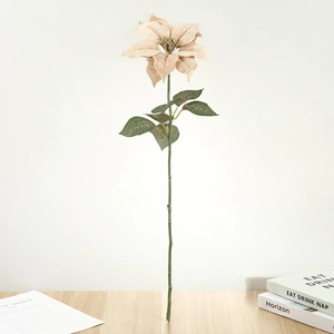 Détail d'un poinsettia artificiel champagne avec longue tige sur une table en bois