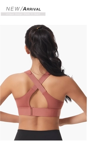 Close-up of rose red sports bra with criss-cross back straps and adjustable hook-and-eye closure