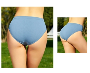 Macro detail of seamless ribbed blue cotton panty showing elastic knit texture on grass