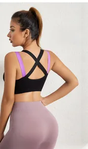 Detail of cross-back black sports bra with purple straps and seamless yoga leggings