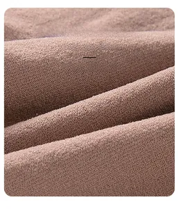 Macro detail of the soft, light brown knitted fabric texture with delicate fibers