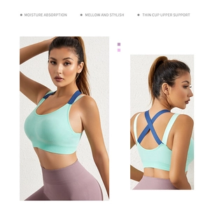 Detail of mint green sports bra with blue straps showing cross back and moisture wicking fabric