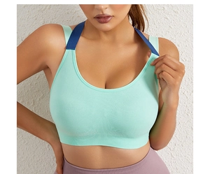 Close-up of mint green sports bra with navy blue racerback straps and ribbed wide hem