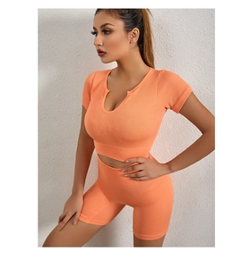 Dettaglio della trama a costine sul set reggiseno sportivo e pantaloncini arancione corallo