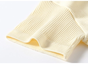 Dettaglio dei polsini in maglia a coste di un reggiseno sportivo color crema
