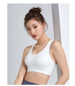 Detailed view of white wire-free sports bra with wide elastic band and U-neckline
