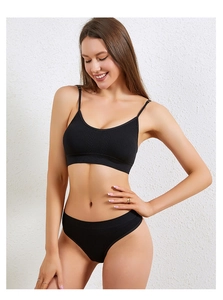 Vista frontale di reggiseno nero senza cuciture e slip coordinati su una modella
