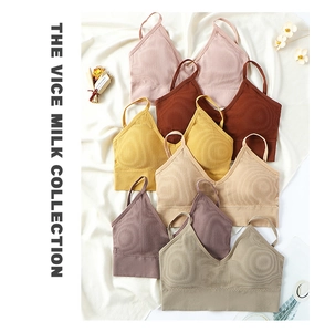 Flat lay of ribbed seamless V-neck bras in various earthy tones on white fabric