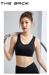 Rear view of black seamless sports bra and high-waisted leggings set on model