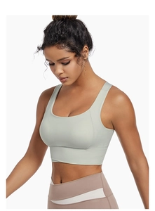 Close-up of light green sports bra featuring wide straps and seamless stitching details