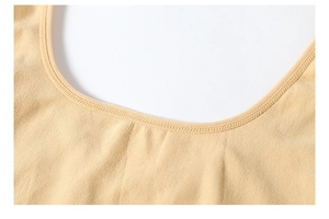 Detail of the skin-tone bodysuit featuring a deep U-neckline and elastic hem stitching