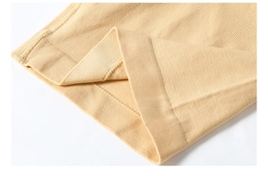 Detailed close-up of seamless skin-tone fabric with ribbed elastic waistband and fine knit texture
