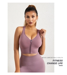 Détail du zip frontal sur brassière de sport rose avec bretelles larges et tissu stretch