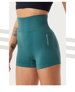 Close-up of high-waist seamless yoga shorts in dark green with side brand logo
