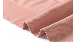 Gros plan du tissu côtelé rose du soutien-gorge de yoga montrant douceur et élasticité