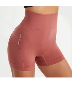Detailed view of coral pink high-waisted seamless yoga shorts with white side lettering