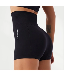 Detail showing high-waisted seamless yoga shorts with peach lift design and side branding