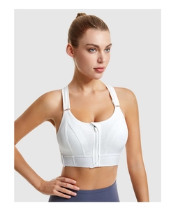 Detailed close-up of white sports bra with front zipper closure and breathable mesh fabric