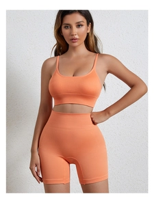 Detail van oranje hoog-elastische geribde gebreide sport-bh en shorts set voor yoga